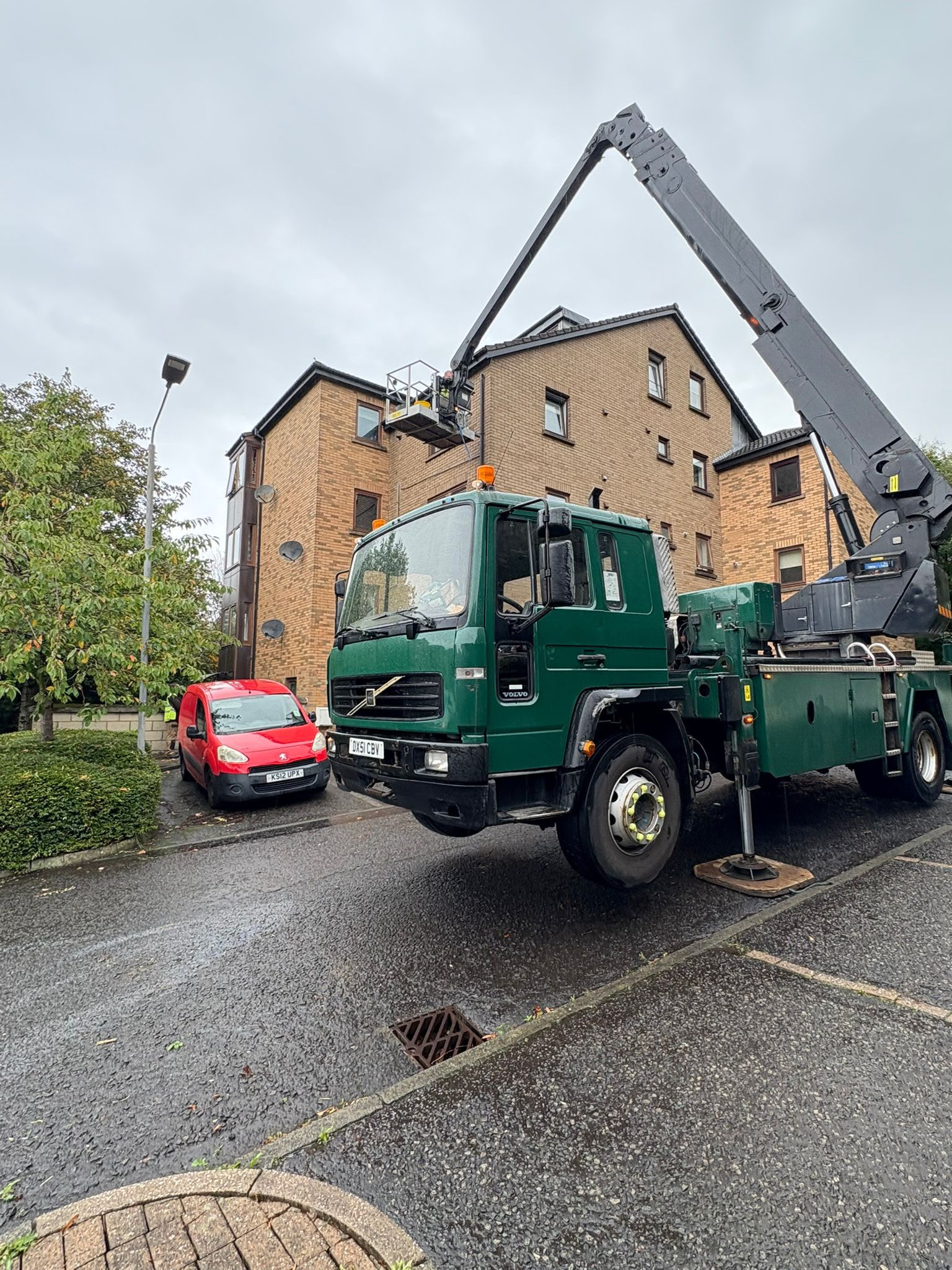 Volvo truck mounted MEWP cherry picker hire setup with outriggers extended in a Glasgow residential estate