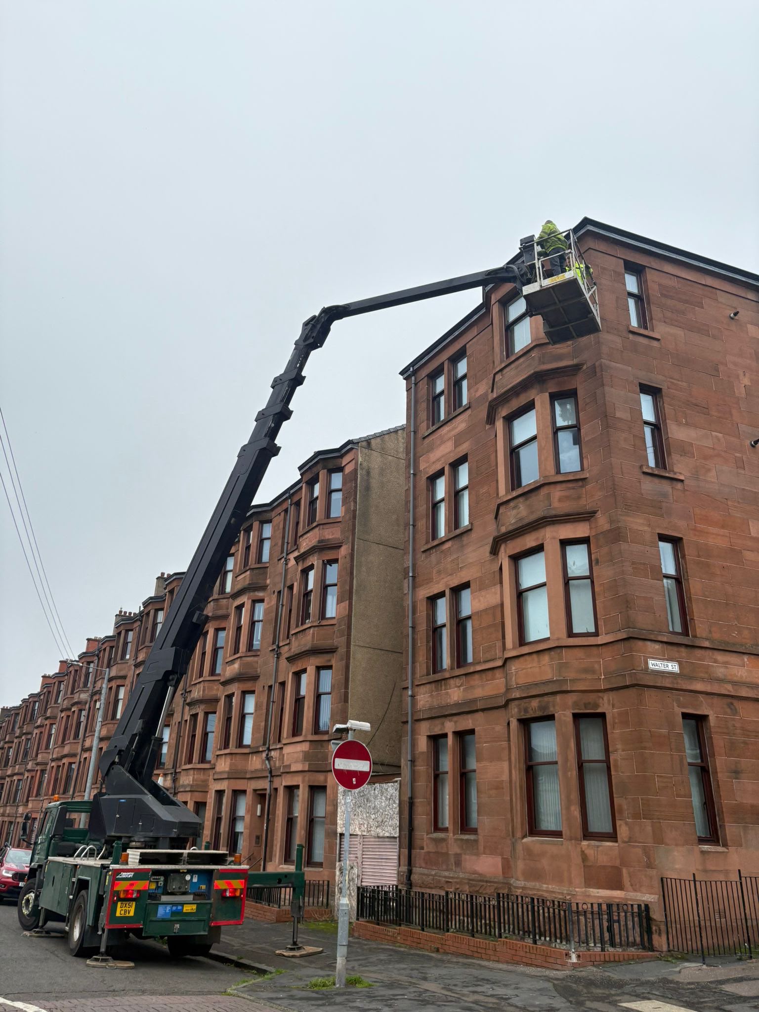 Truck mounted access platform hire deployed on a red sandstone tenement street in Glasgow